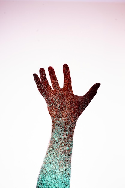 Digital composite image of hand with chocolate sprinkles against white background