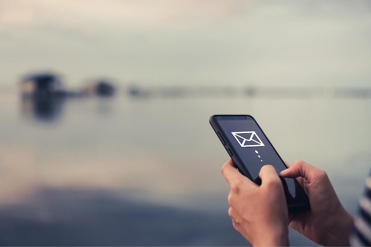 Foto digital composite image of person using mobile phone with icons against lake and sky