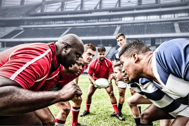 Digital composite image of team of rugby players facing each other in sports stadium