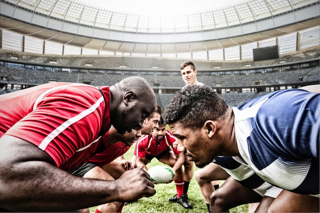 Digital composite image of team of rugby players facing each other in sports stadium