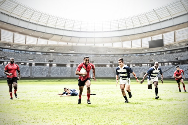 Immagine composita digitale della squadra di giocatori di rugby che giocano a rugby nello stadio sportivo