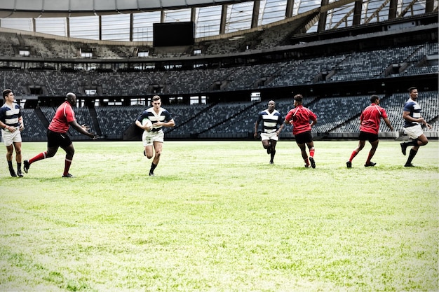 Digital composite image of team of rugby players playing rugby in sports stadium