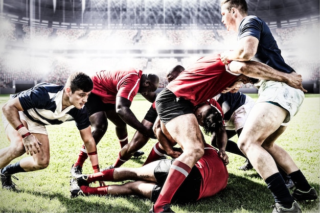 Immagine composita digitale della squadra di giocatori di rugby che si affrontano per vincere la palla negli stadi sportivi