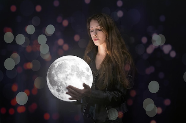 Foto immagine composita digitale di una giovane donna che tiene la luna piena