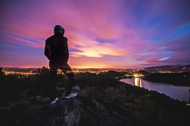 Foto composito digitale di un uomo in piedi sulla terra contro il cielo durante il tramonto