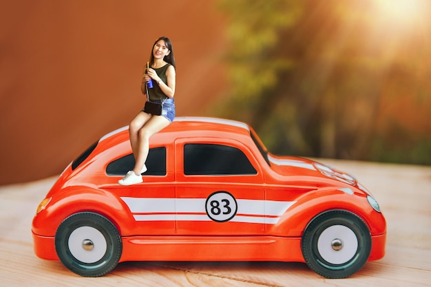 Digital composite portrait of woman sitting on red toy car at table