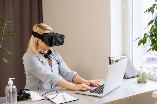 Digital composite of woman playing with computer game controller and Virtual reality headset with bright blurred background