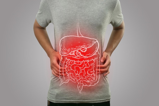 腹痛の健康と医療のコンセプトを持つ病人の男性に赤い炎症が強調された内部消化器系のデジタル構成