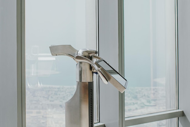 Digital electronic telescope of the Burj Khalifa standing alone at the observation deck