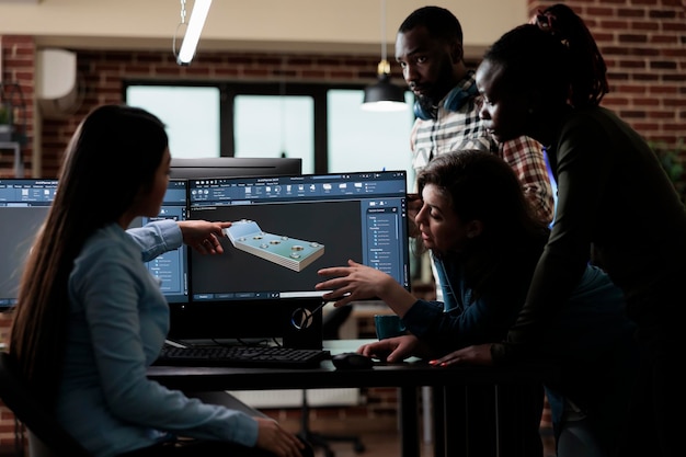 Digital engineering experts collaborating in order to develop\
advanced scene. production department team gathered around 3d\
artist engineer trying to solve geometry problem.