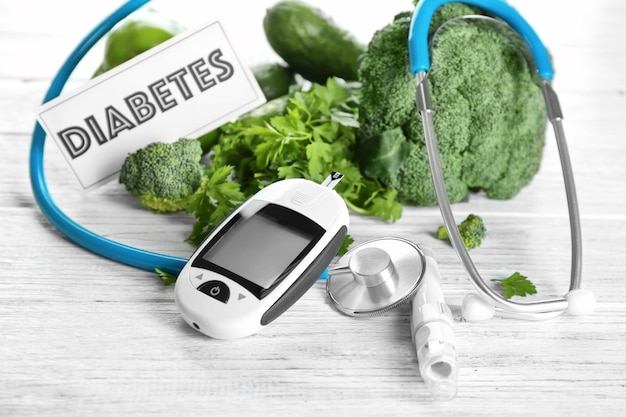 Digital glucometer lancet pen stethoscope and vegetables on table Diabetes diet