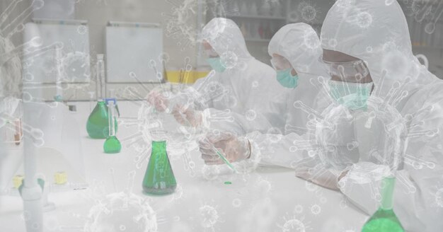 Digital illustration of scientists wearing face masks,\
protective suits, gloves and googles, working in a laboratory over\
macro coronavirus covid-19 cells floating in the background.\
medicine public h