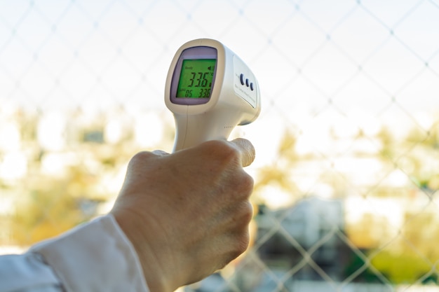 Foto pistola termometro termometro digitale a infrarossi per lo screening della misurazione della temperatura sulla fronte