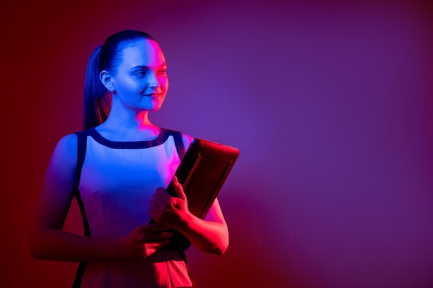 Digital lifestyle Futuristic technology Virtual business Curious smart confident woman with laptop in pink blue fluorescent neon light isolated on purple empty space background