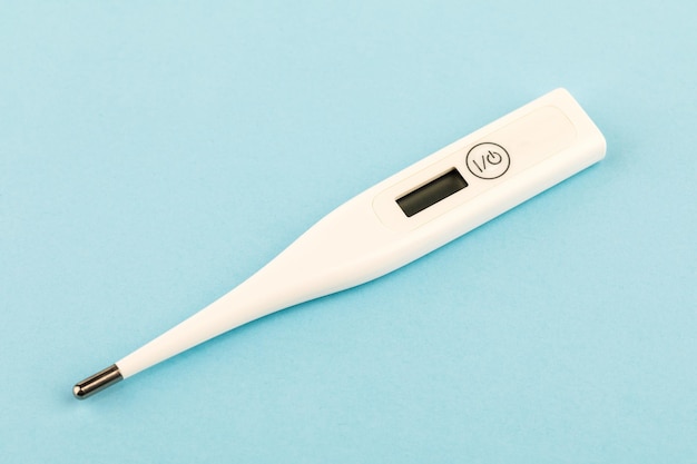 Digital medical thermometer. On a blue background.