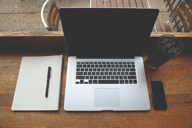 Photo digital native smiling indian businessman working on laptop in modern office