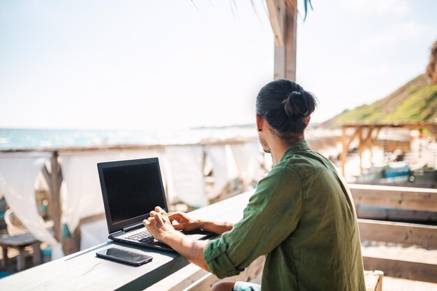 Digital nomad on the beach enjoying his day