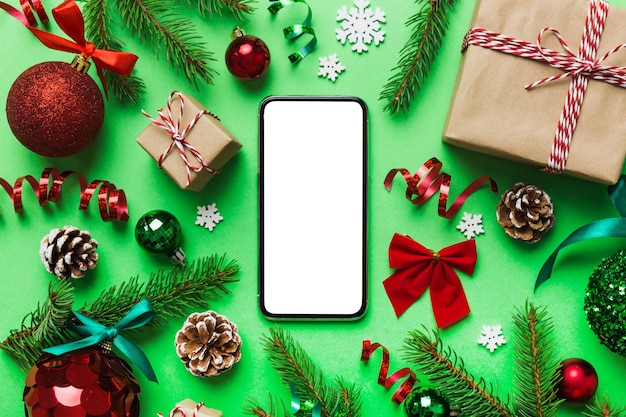 Digital phone mock up with rustic Christmas decorations for app presentation top view with empty space for you design Christmas online shopping concept Tablet with copy space on colored background