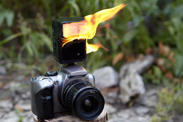 Digital SLR camera with zoom lens and burning electronic on-camera flash.