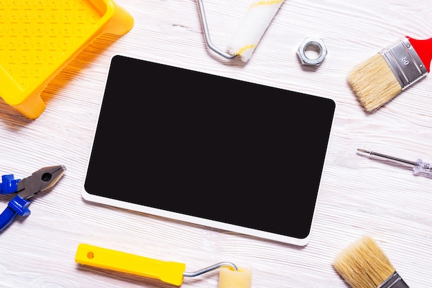 Digital tablet and building tools on wooden desk