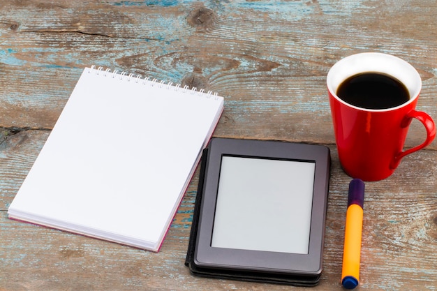 Digital Tablet Computer with Blank White Screen as Copy Space and a cup of coffee on wooden background.