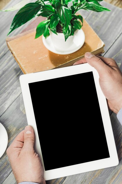 Digital tablet computer with isolated screen in male hands over cafe background - table,