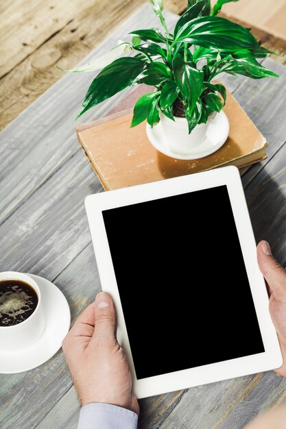 Digital tablet computer with isolated screen in male hands over cafe background - table,