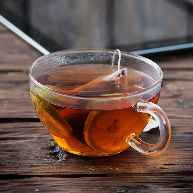 Foto compressa di digital e tazza di tè sulla vecchia tavola di legno
