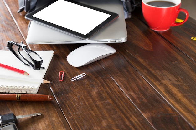 Digital tablet, laptop computer and notebook on office desk