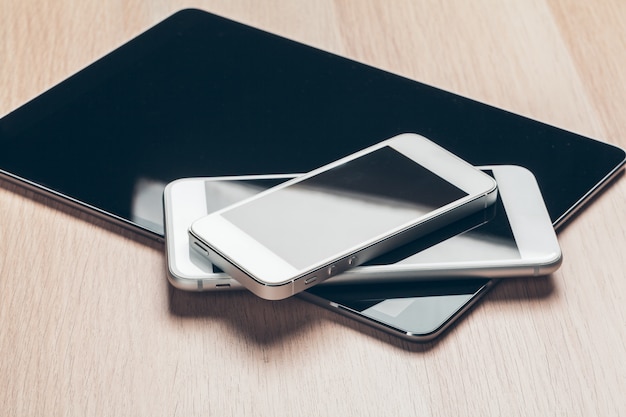 Digital tablet and mobile phone, Electronic devices on wooden table, close up,