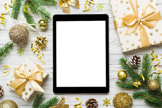 Digital tablet mock up with rustic christmas decorations for\
app presentation top view with empty space for you design christmas\
online shopping concept tablet with copy space on colored\
background