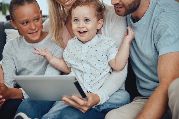 Photo digital tablet relax and happy family on sofa streaming a movie online together at their home happiness fun and parents with their children watching video on the internet or social media on mobile