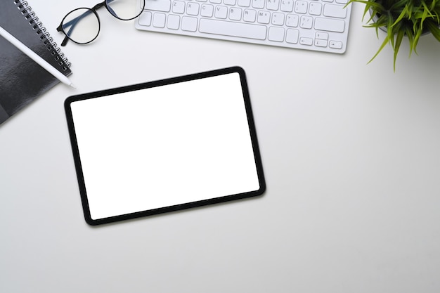 Digital tablet with empty screen on white office desk.