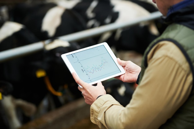 Digital tablet with graphic information on screen in hands of farmer