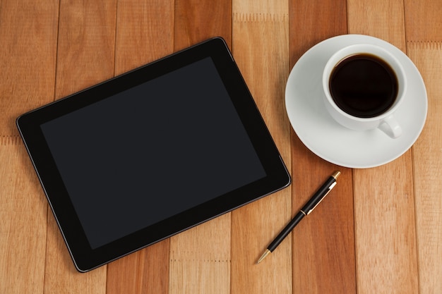 Digital tablet with pen and cup of tea