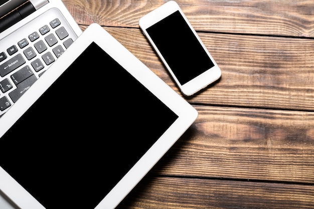 Digital tablet with phone on wooden table in office