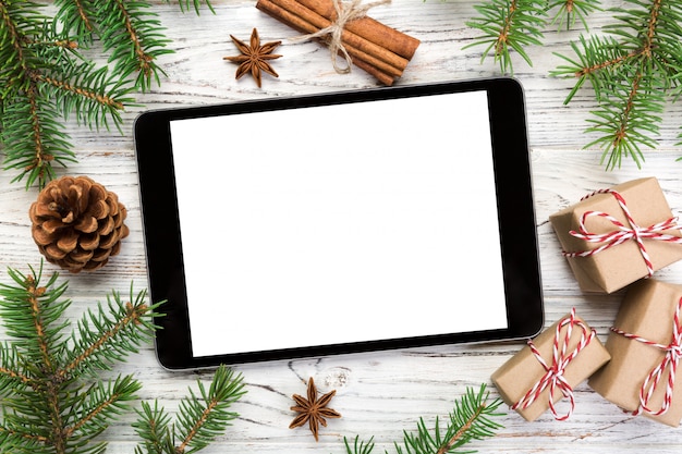 Digital tablet with rustic Christmas wooden decorations for app presentation. top view