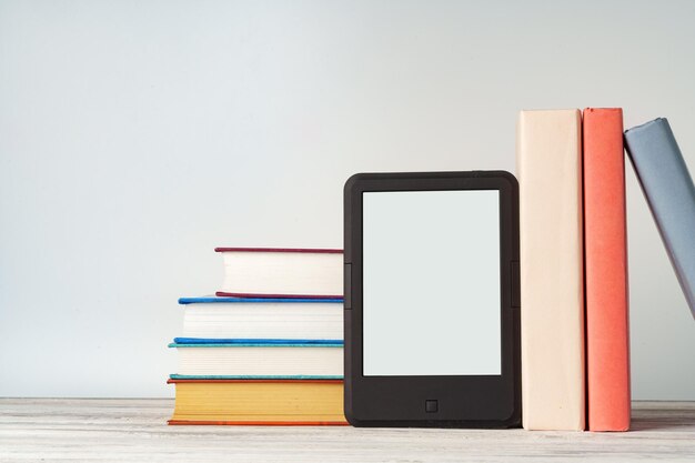 Photo digital tablet with a stack of books on gray background