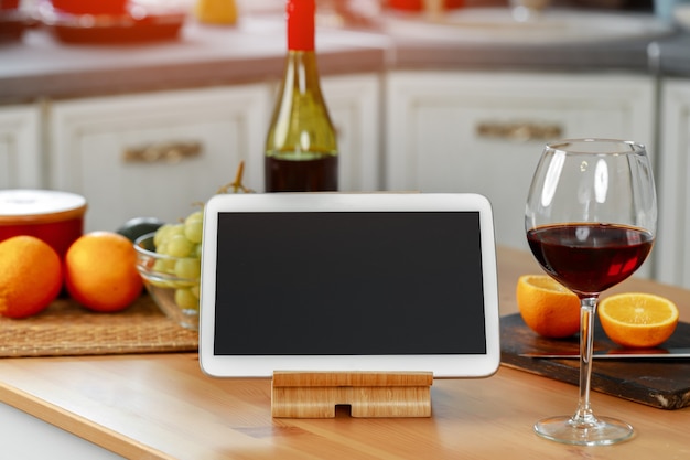 Digital tablet on wooden stand on kitchen counter