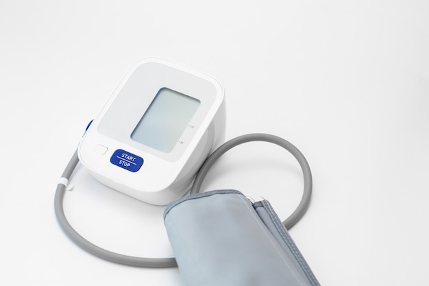 白い壁にデジタル血圧計。血圧の測定。
