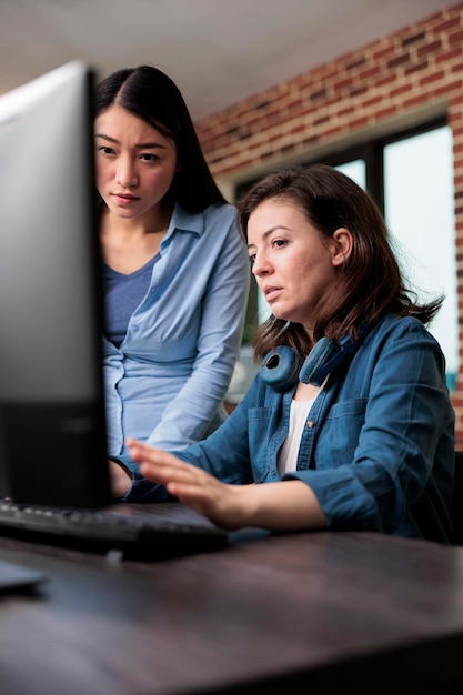 Digitale artiest die om hulp vraagt aan een collega met betrekking tot het project in een moderne werkruimte. werknemer van het ontwerpbedrijf die hulp vraagt aan de teamleider van de productieafdeling terwijl hij op kantoor is.