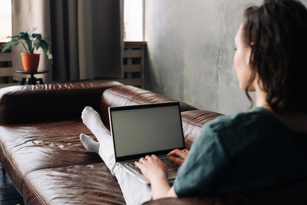 Digitale connectiviteit en productiviteit jonge vrouw gebruikt thuis een laptop met een leeg wit scherm