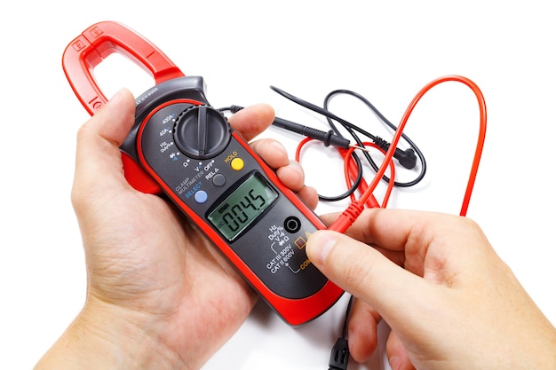 Digitale klemmultimeter met sondes in mensenhand op wit