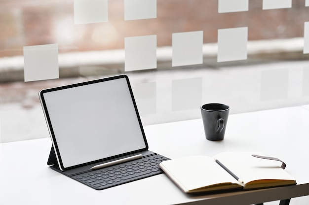 Digitale tablet, laptop en koffie op het bureau.