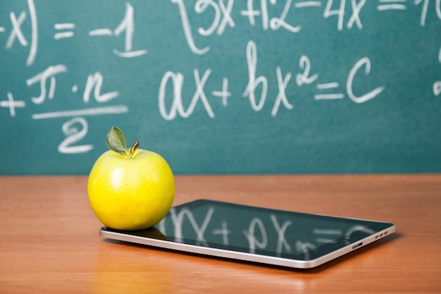 Digitale tablet met rijpe groene appel op tafel