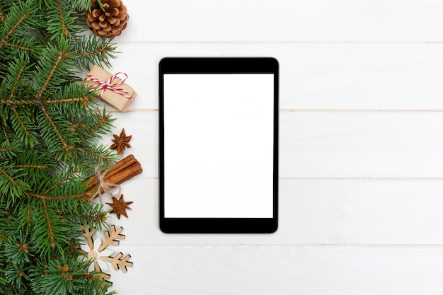Digitale tablet met rustieke Kerstmis houten decoratie als achtergrond voor app presentatie. bovenaanzicht met copyspace