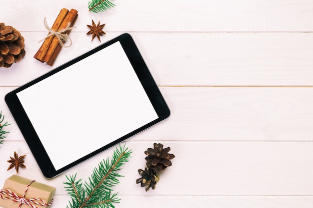 Digitale tablet met rustieke Kerstmis houten decoratie als achtergrond voor app presentatie. bovenaanzicht vintage, afgezwakt met copyspace