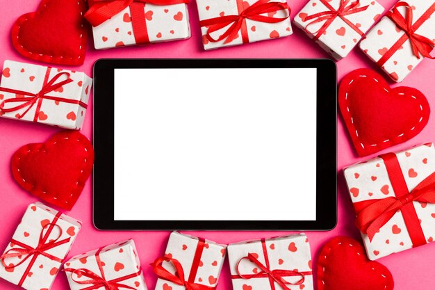 digitale tablet omringd met geschenkdozen en harten