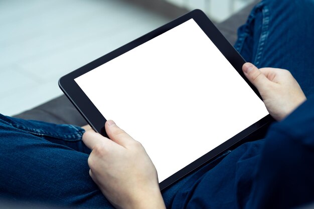 Digitale tabletcomputer met leeg wit scherm in mannelijke handen van bovenaf bekijken close-up Jonge kerel werkt thuis aan gadget