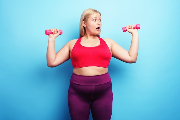 Dik meisje doet aan gym maar maakt zich zorgen om iets op cyaan